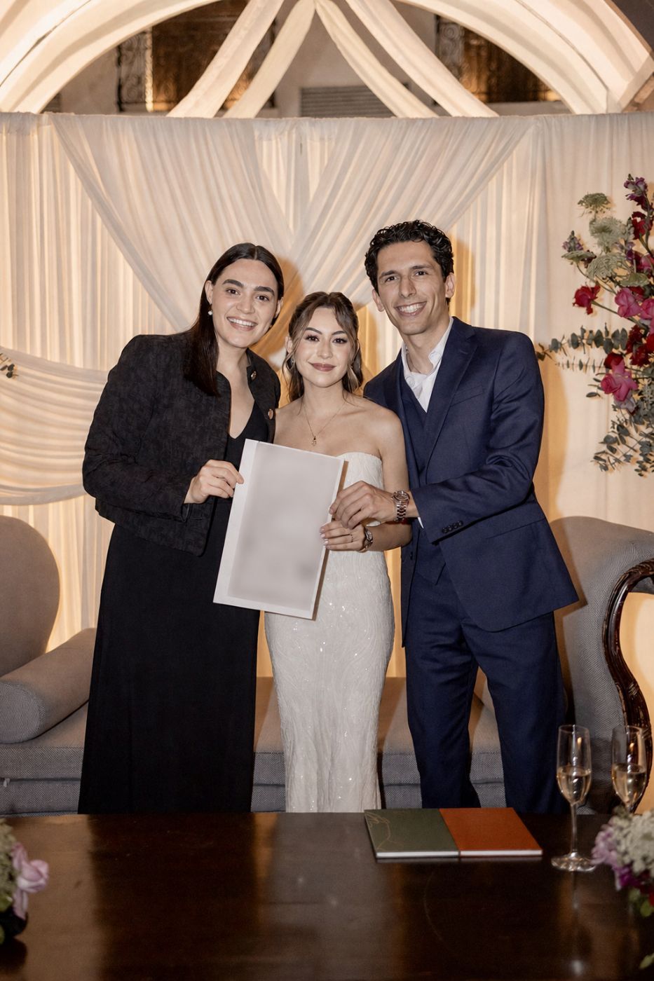 Novios con su acta de matrimonio junto a la jueza que ofició su ceremonia